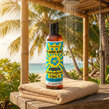 Bottle of Island Breeze Super Moisturizing Oil on a towel with a tropical beach background
